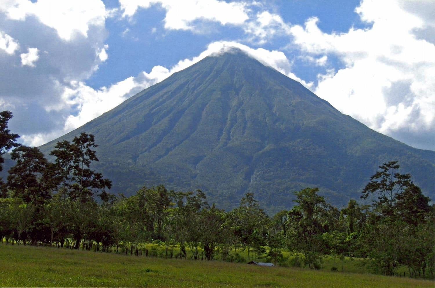 The cone of Arenal volcano rising over the rainforest